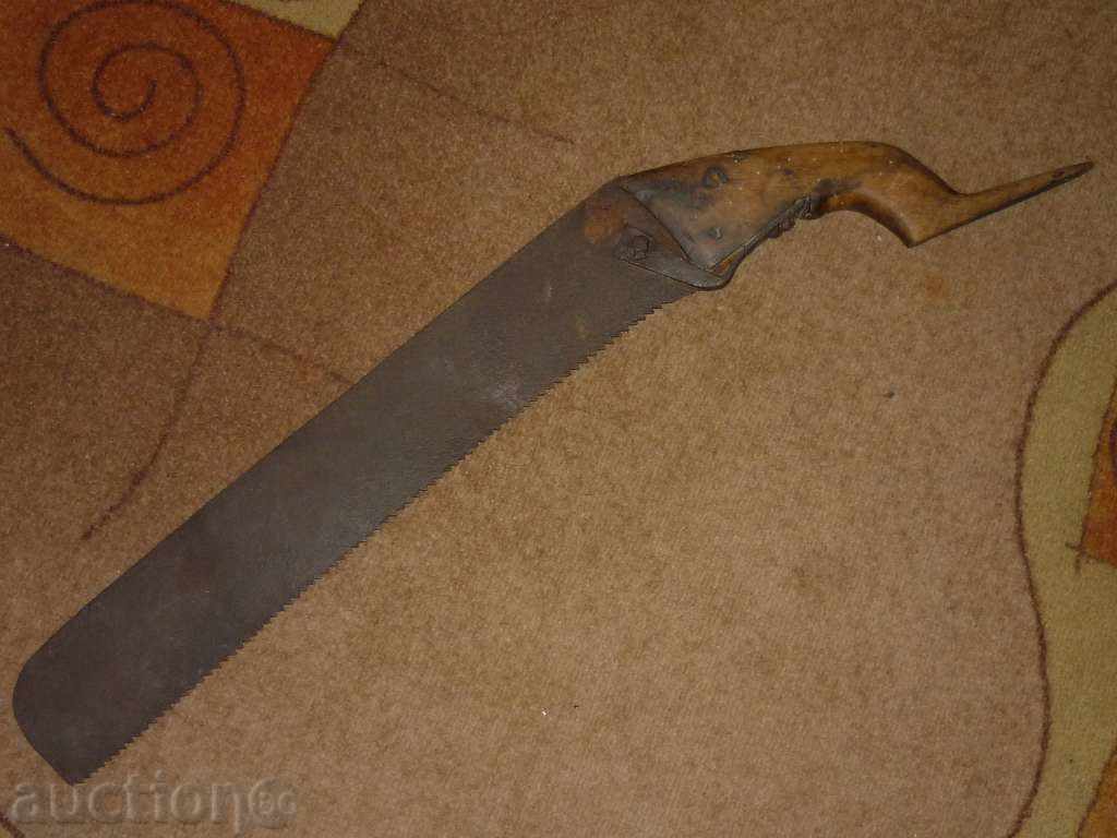 A primitive wooden saw with a metal strip