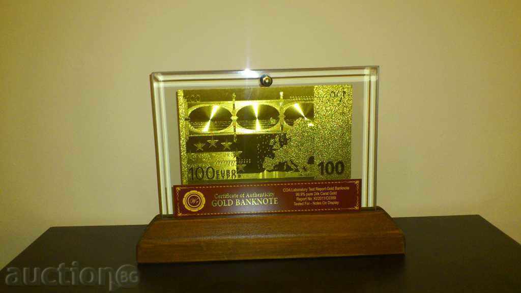 100euro golden banknote in a glass stand and solid wood