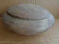 An old wooden bowl, a wooden saucer, a pan with a lid, the wooden one