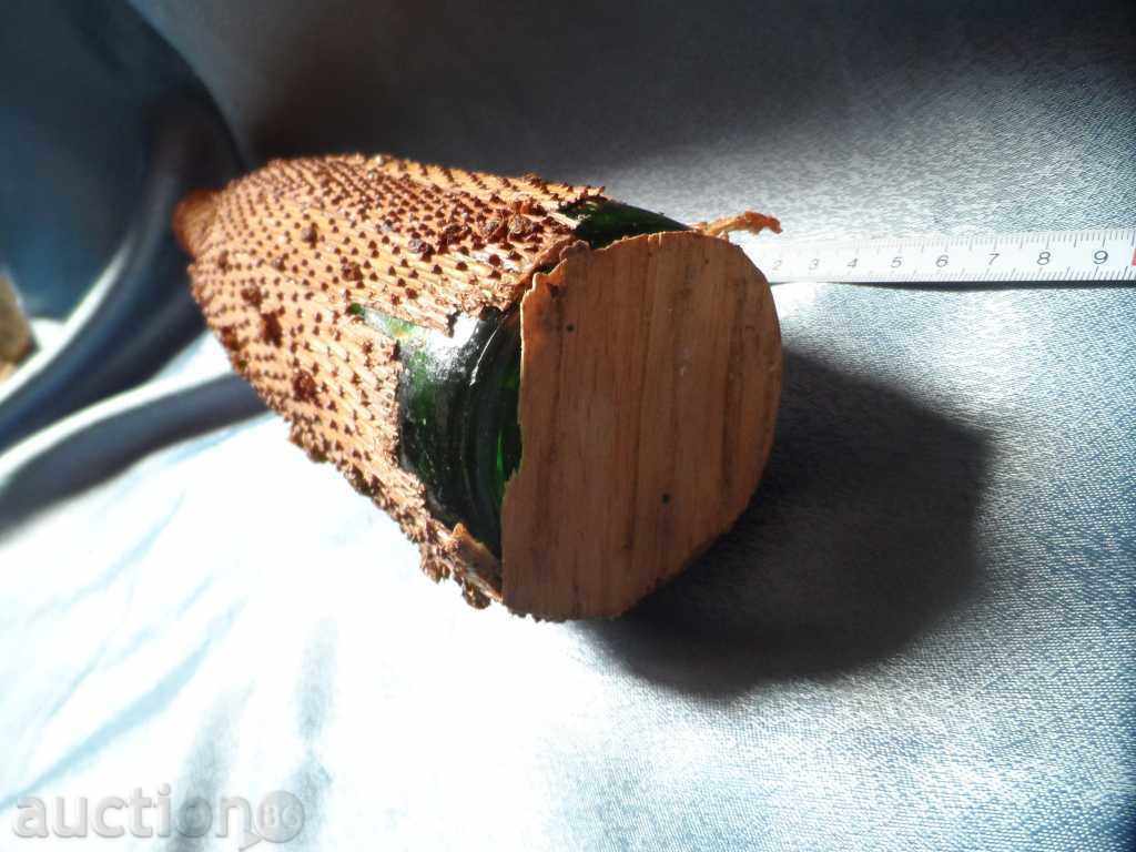 Delivery of an old glass bottle decorated with the bark of a coniferous tree Delivery of an old glass bottle decorated with the bark of a coniferous tree
