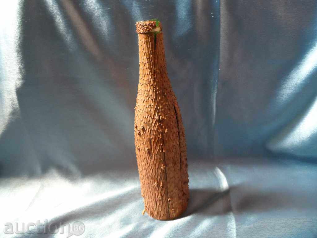 an old glass bottle decorated with the bark of a coniferous tree