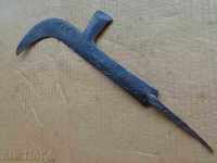 An old hand-forged hammer with primitive engravings, wrought iron