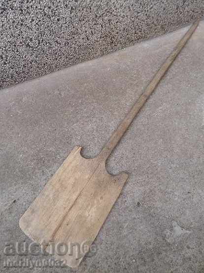An old wooden shovel, a blade, a wood-burning wood