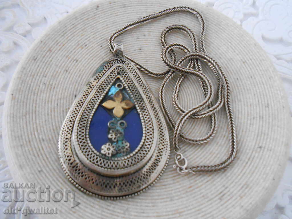 A very old silver necklace with a large locket