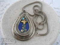 A very old silver necklace with a large locket