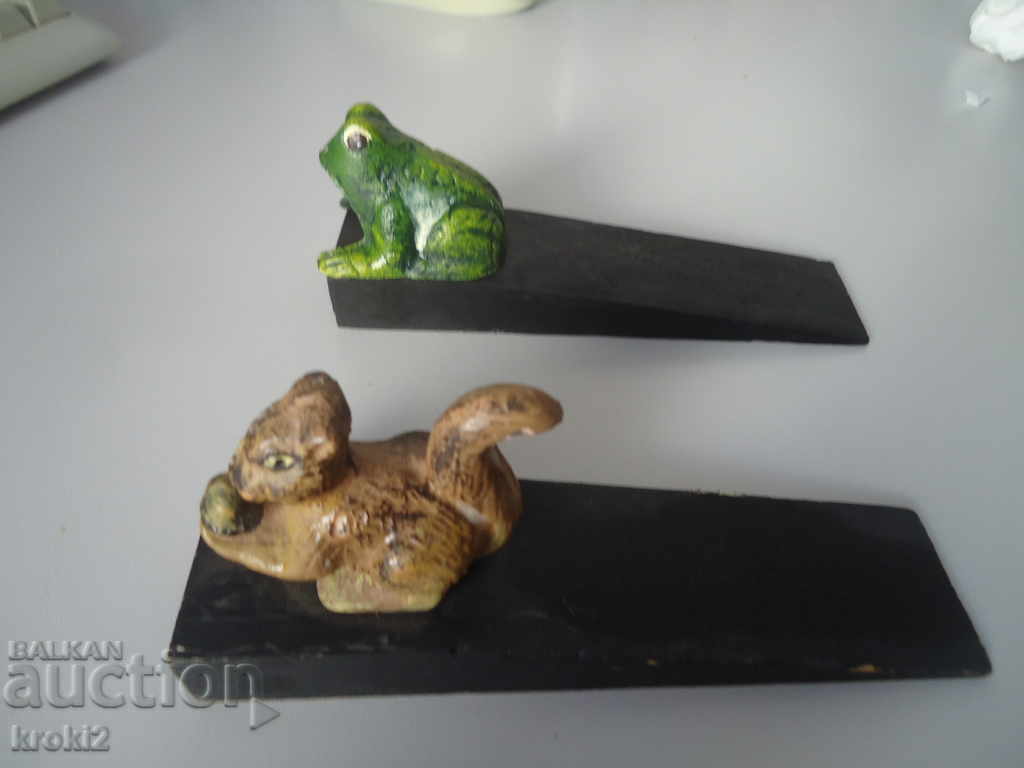 Two cast iron door stoppers on a wooden frog base Two cast iron door stoppers on a wooden frog base