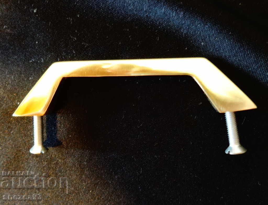 Brass handle for furniture.