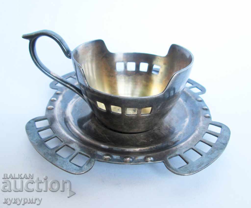 An old silver cup with a dish decorated Art Deco