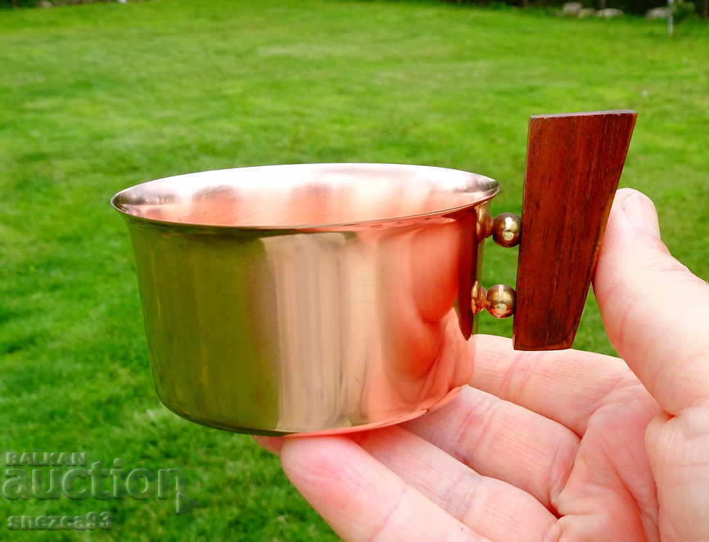 Copper cup with natural wood handle.