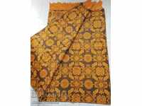 Veche cuvertură galbenă, covor pestriț