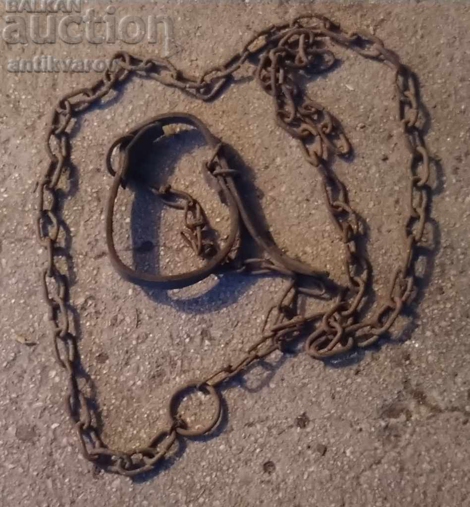 An old chain with a thick leather cattle strap