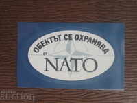 Obiectul este păzit de autocolant NATO