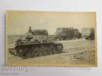 Fotografie veche cu un tanc german și camioane din al doilea război mondial