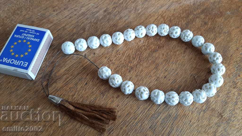 A bead of porcelain string with a leather tassel