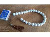 A bead of porcelain string with a leather tassel
