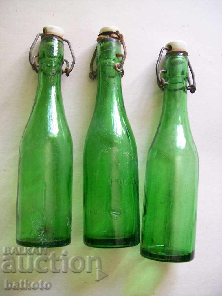 Πολλά μπουκάλια λεμονάδας - πράσινο ποτήρι
