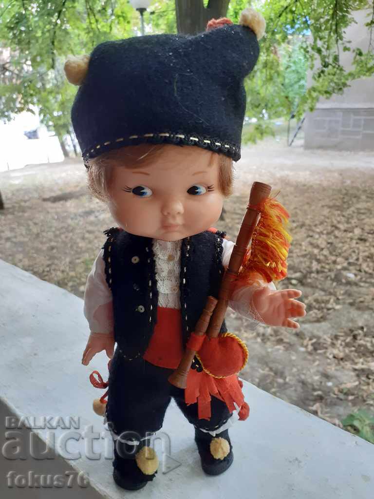 Old rubber doll in a bagpipe costume -