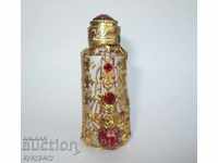 Old antique perfume bottle with ornaments and gilding