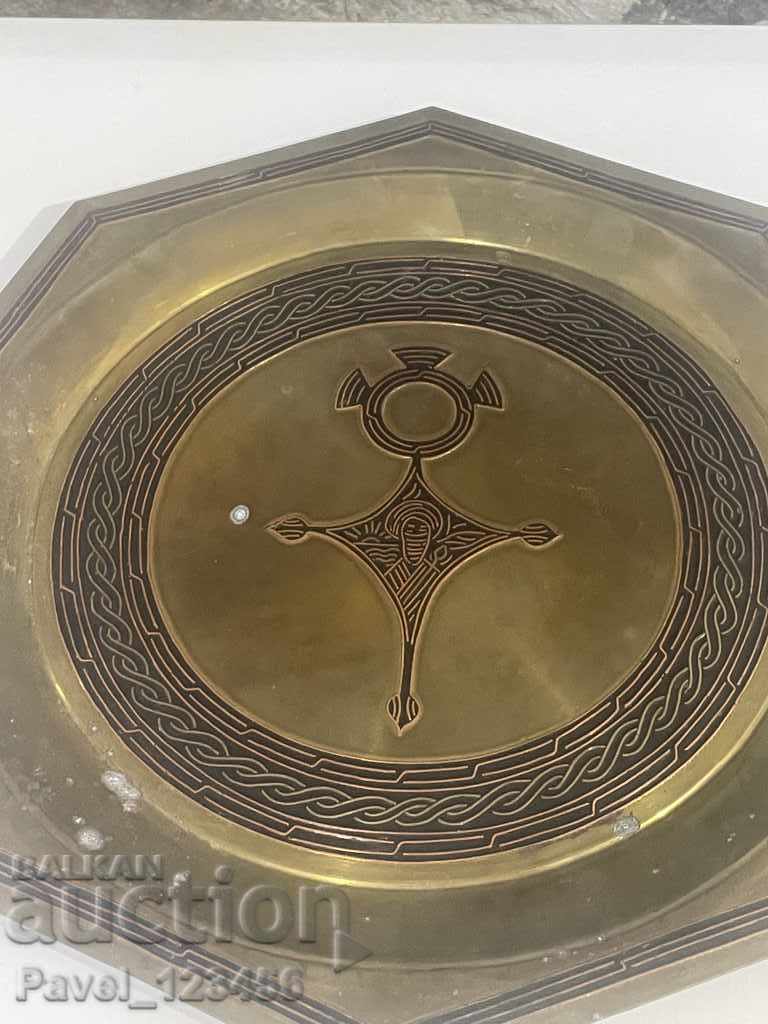 метална чиния за стена със странна символика