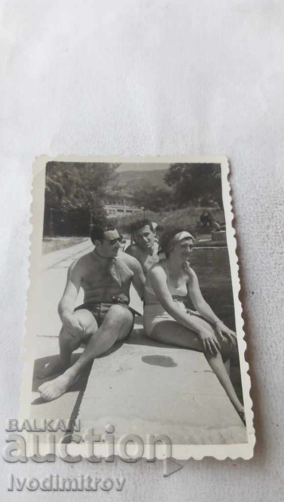 Φωτογραφία Μια γυναίκα και δύο άνδρες κάθονται στο κράσπεδο