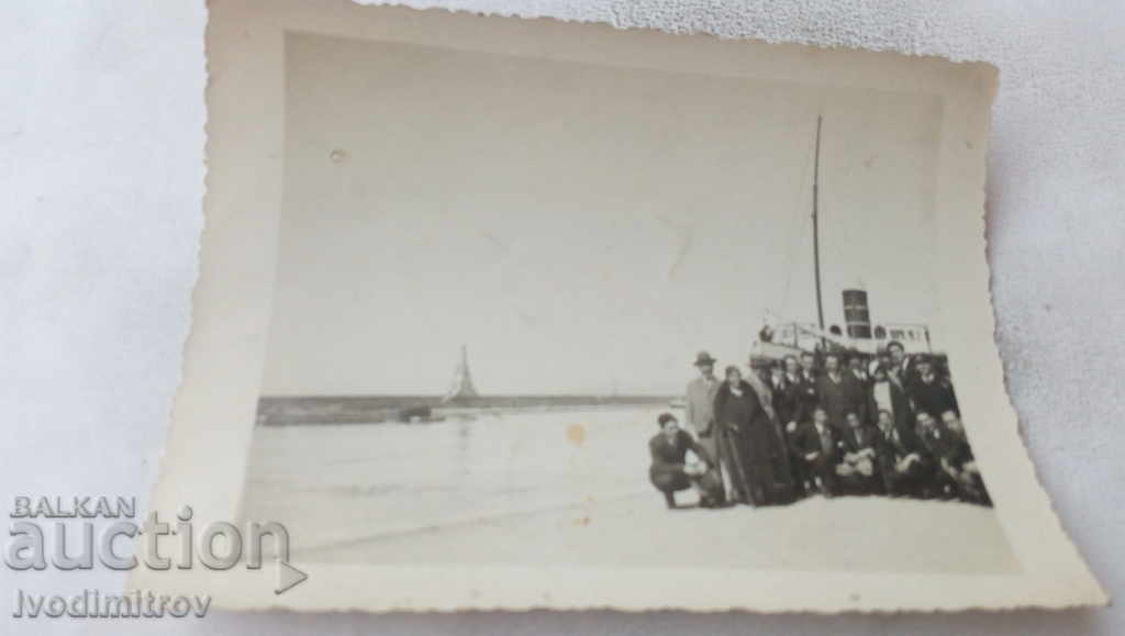 Φωτογραφία Ομάδα ανθρώπων μπροστά από ένα ατμόπλοιο στο λιμάνι