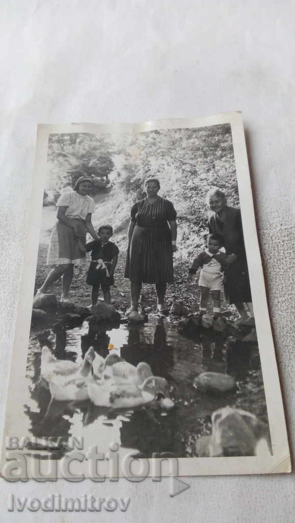 Photo Women and children by the pond with ducks