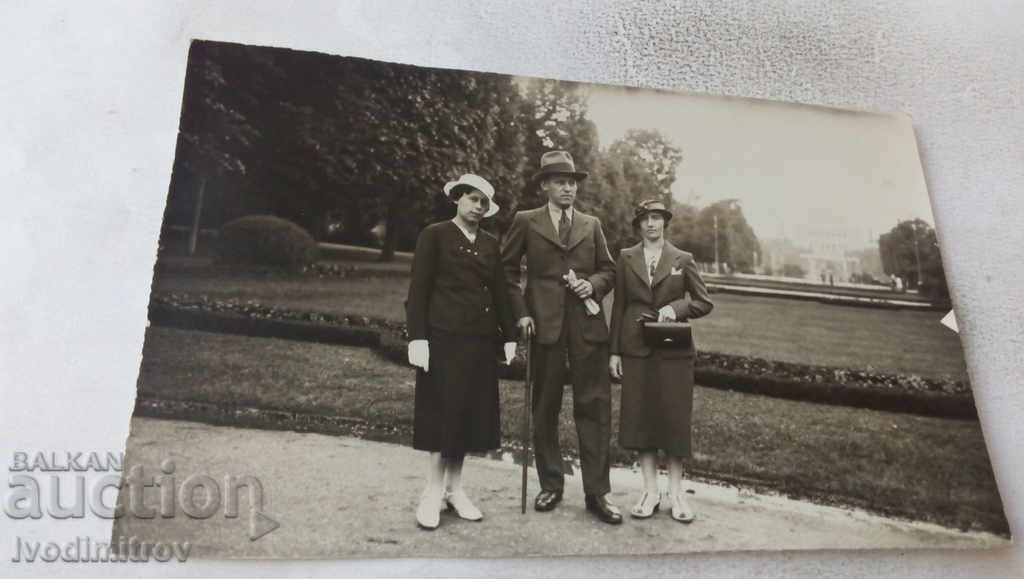 Fotografie cu un bărbat și două femei în parc