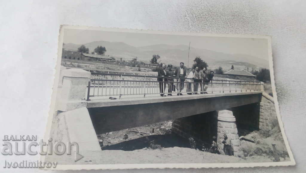 Αξιωματικός φωτογραφιών και πολίτες σε μια γέφυρα πάνω από ένα ποτάμι