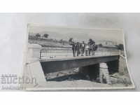 Photo Officer and civilians on a bridge over a river