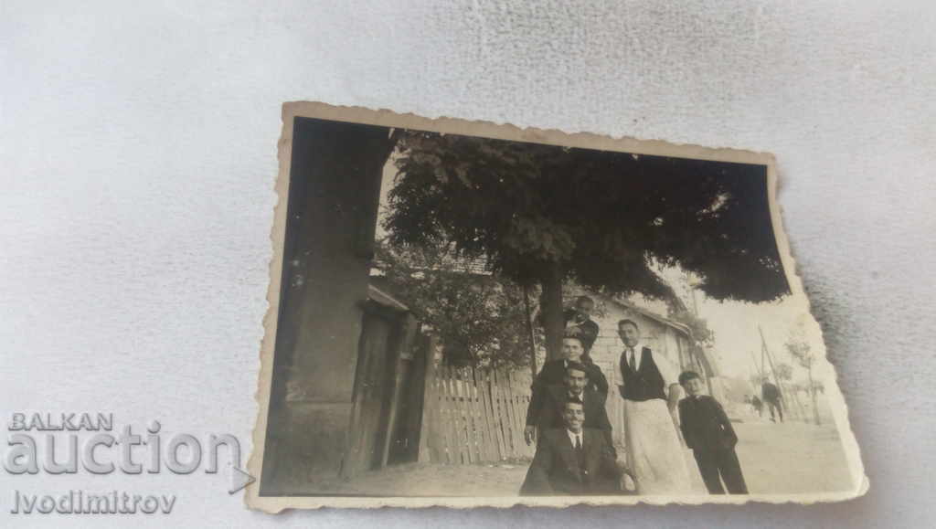 Φωτογραφία Πέντε άντρες και ένα αγόρι στο δρόμο δίπλα στο σπίτι του