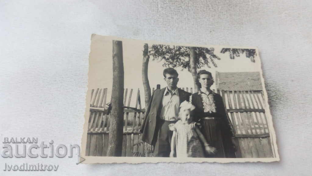 Φωτογραφία Οικογένεια δίπλα στον φράχτη του σπιτιού του