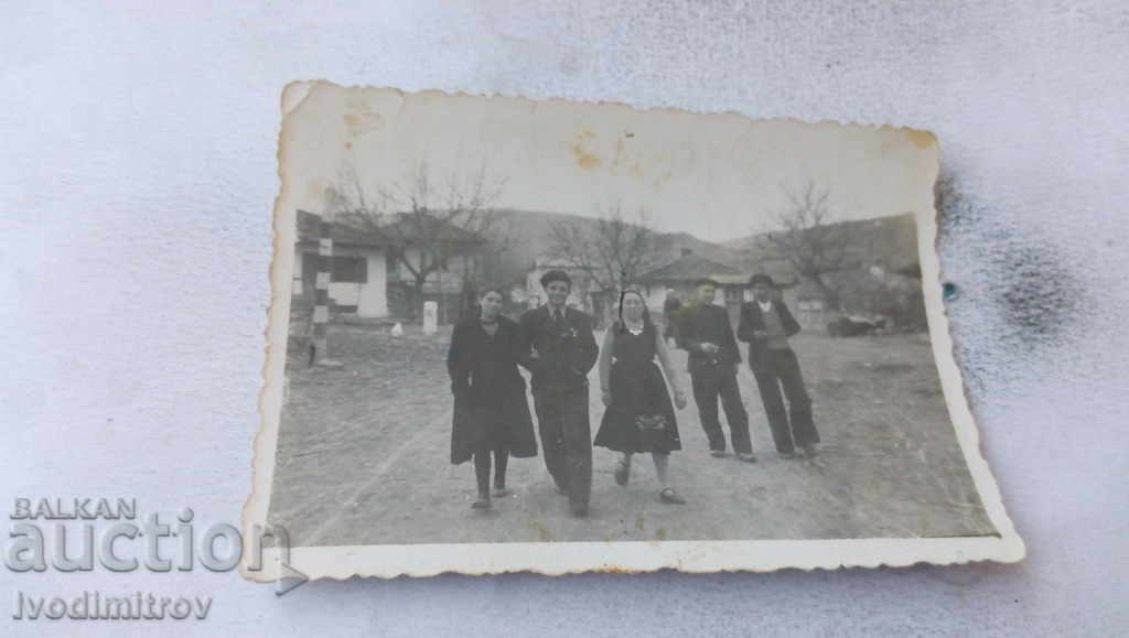Foto Bărbați și femei pe strada principală a satului