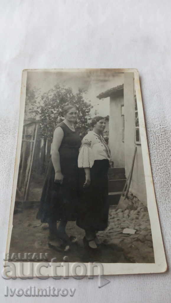 Foto Două femei în curtea casei lui