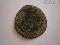 o veche monedă europeană bătută de mașini, cu o gaură pentru simbol