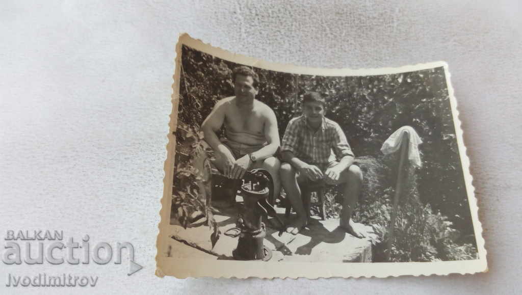 Φωτογραφία Πατέρας και γιος δίπλα σε μια χειροκίνητη αντλία για νερό στην αυλή