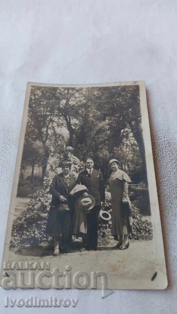 Φωτογραφία ενός άνδρα με κοστούμι και δύο γυναικών