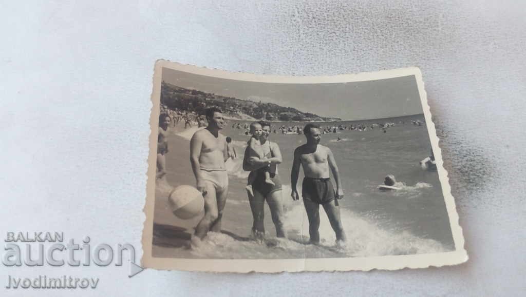 Photo Two men and a woman with a boy on the beach