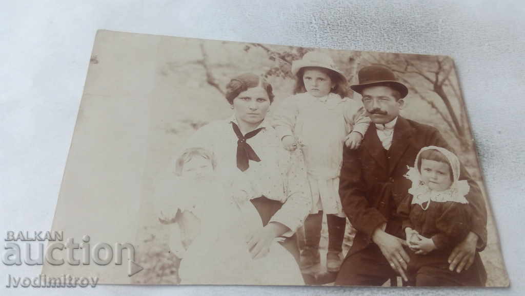 Φωτογραφία ενός άνδρα και μιας γυναίκας με τα τρία κορίτσια τους