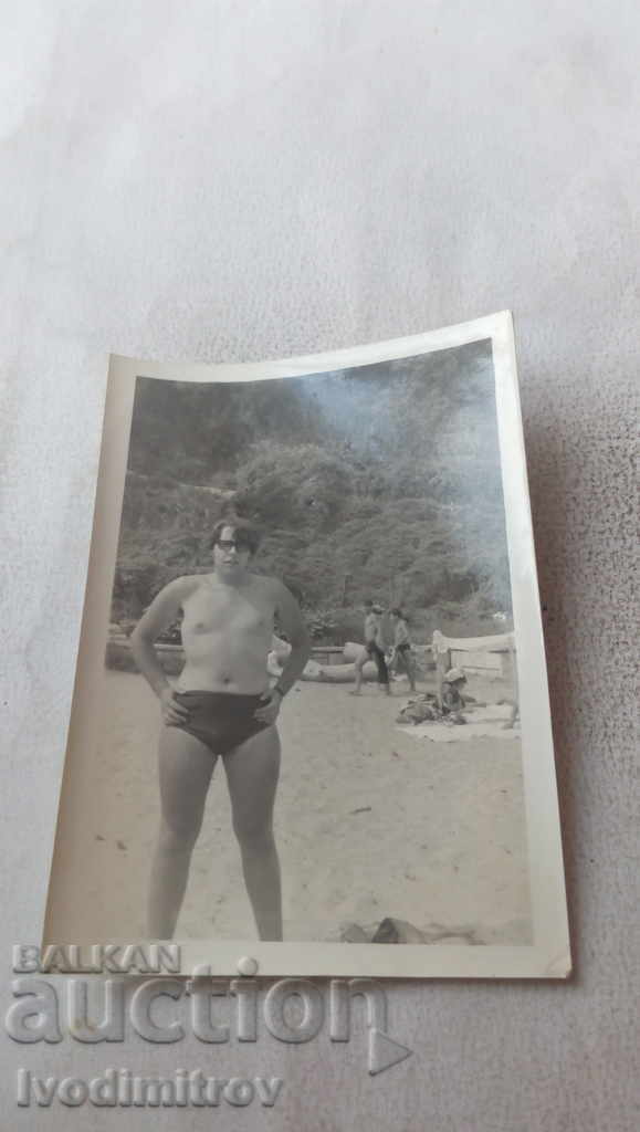 Φωτογραφία Νεαρός άνδρας με μαγιό στην παραλία