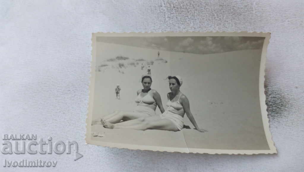 Photo Two women in white swimsuits on the beach