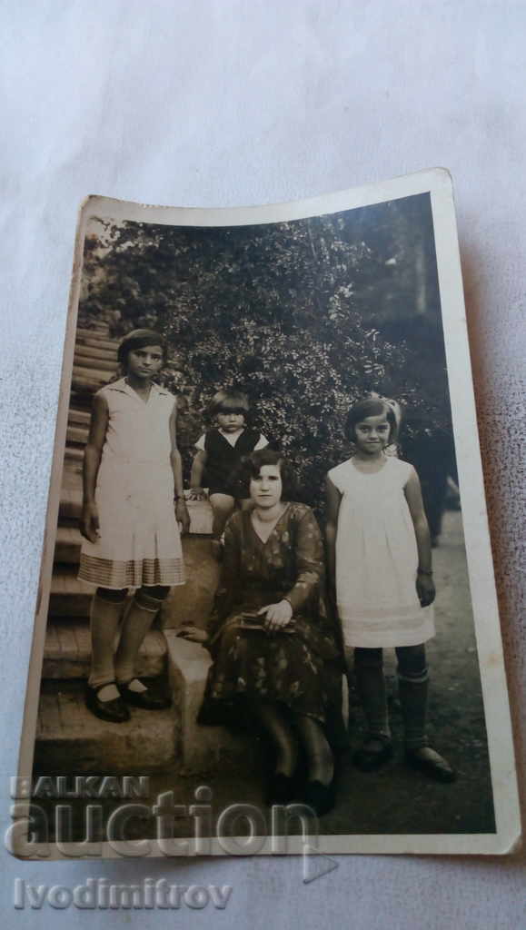 Foto Femeie cu cei trei copii ai săi pe scări