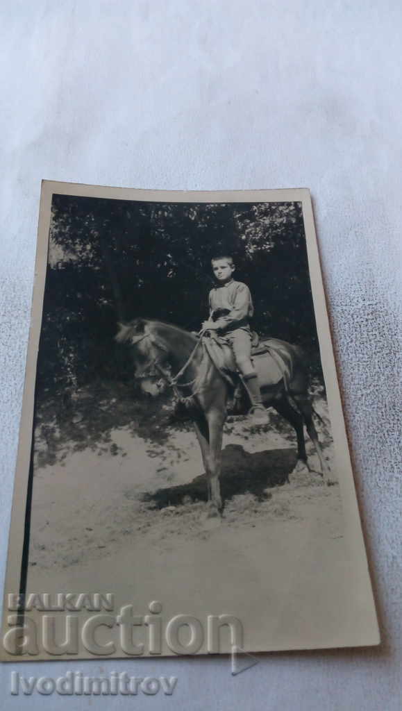 Fotografie cu un băiat pe un cal negru