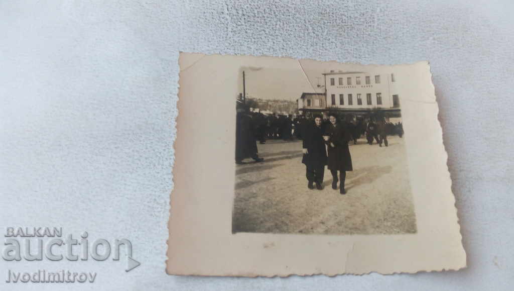 Photo Two young girls in the square in front of the Popular Bank