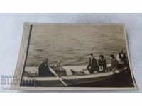 Photo of a man and two young girls in a boat at sea