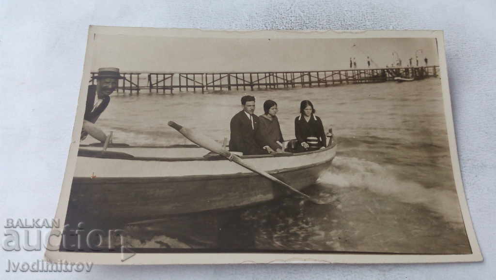 Photo of a man and two young girls in a boat at sea