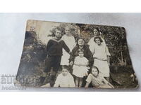 Fotografie O femeie în vârstă cu fete și băieți în curte