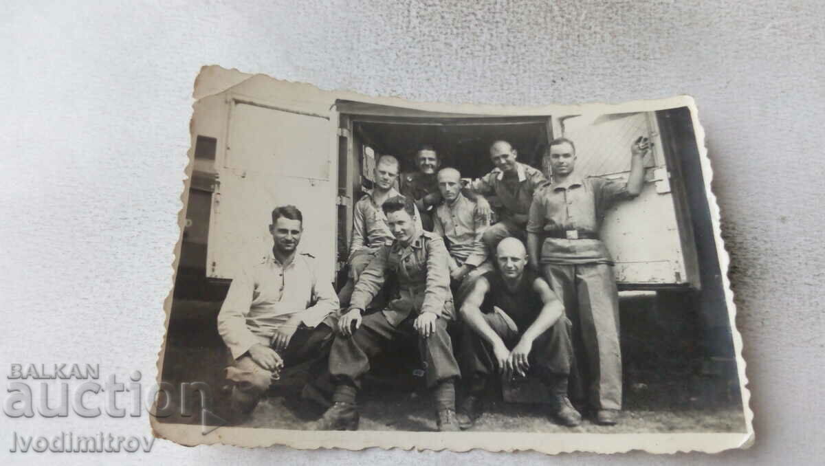 Φωτογραφία Λοχίες και στρατιώτες πίσω από ένα ρετρό φορτηγό