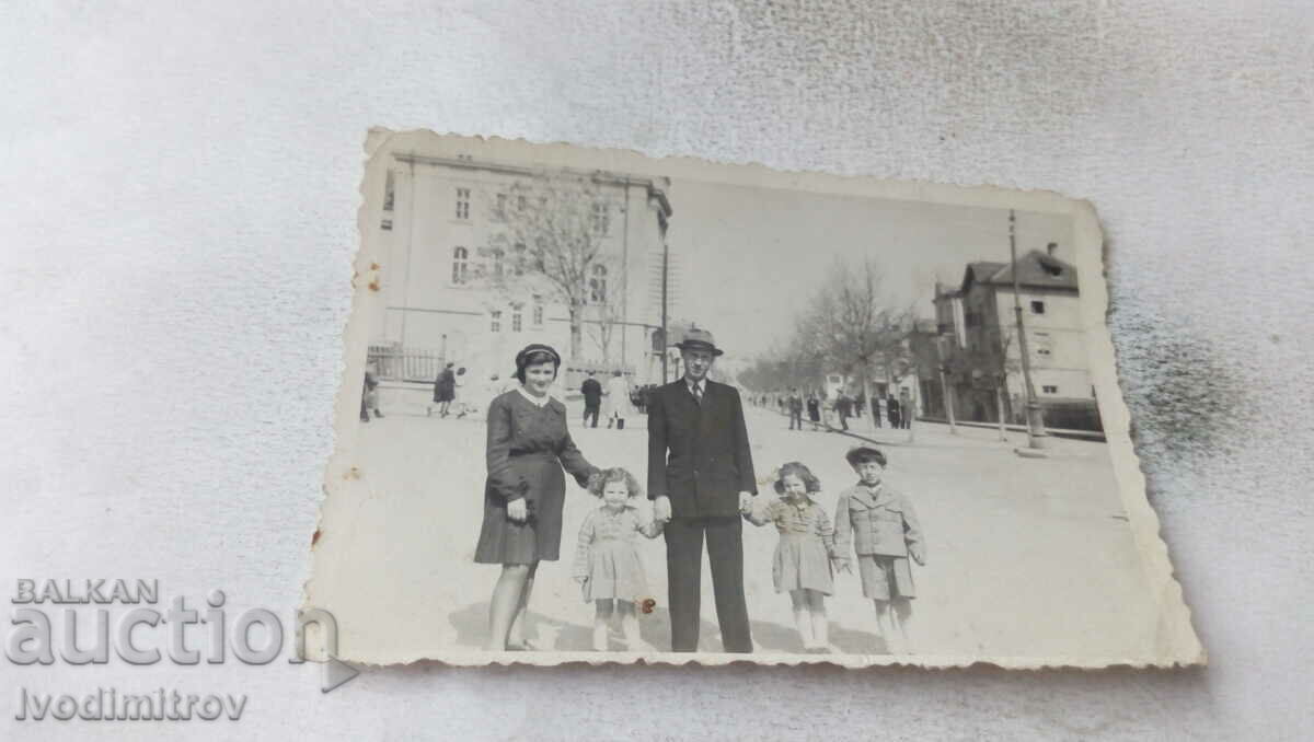 Photo Man and woman with their three children on the street