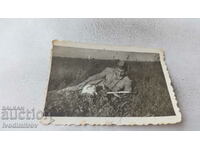 Photo Little kitten and soldier reading a book on the lawn