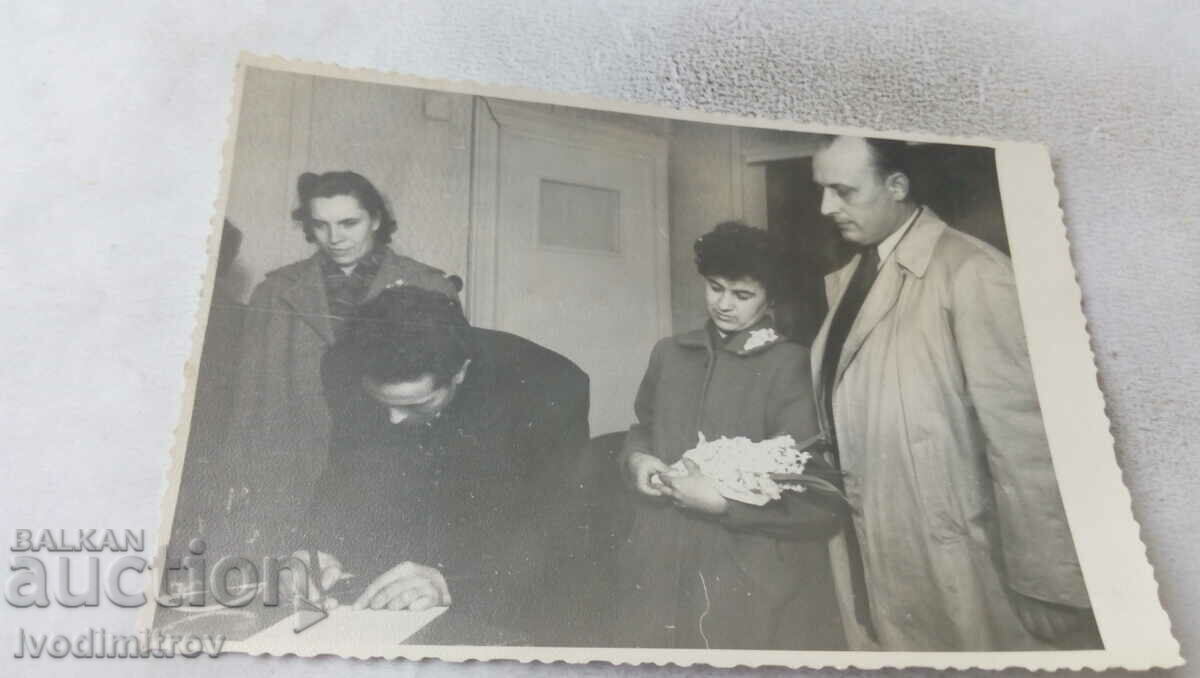 Foto Bărbați și femei semnează un document
